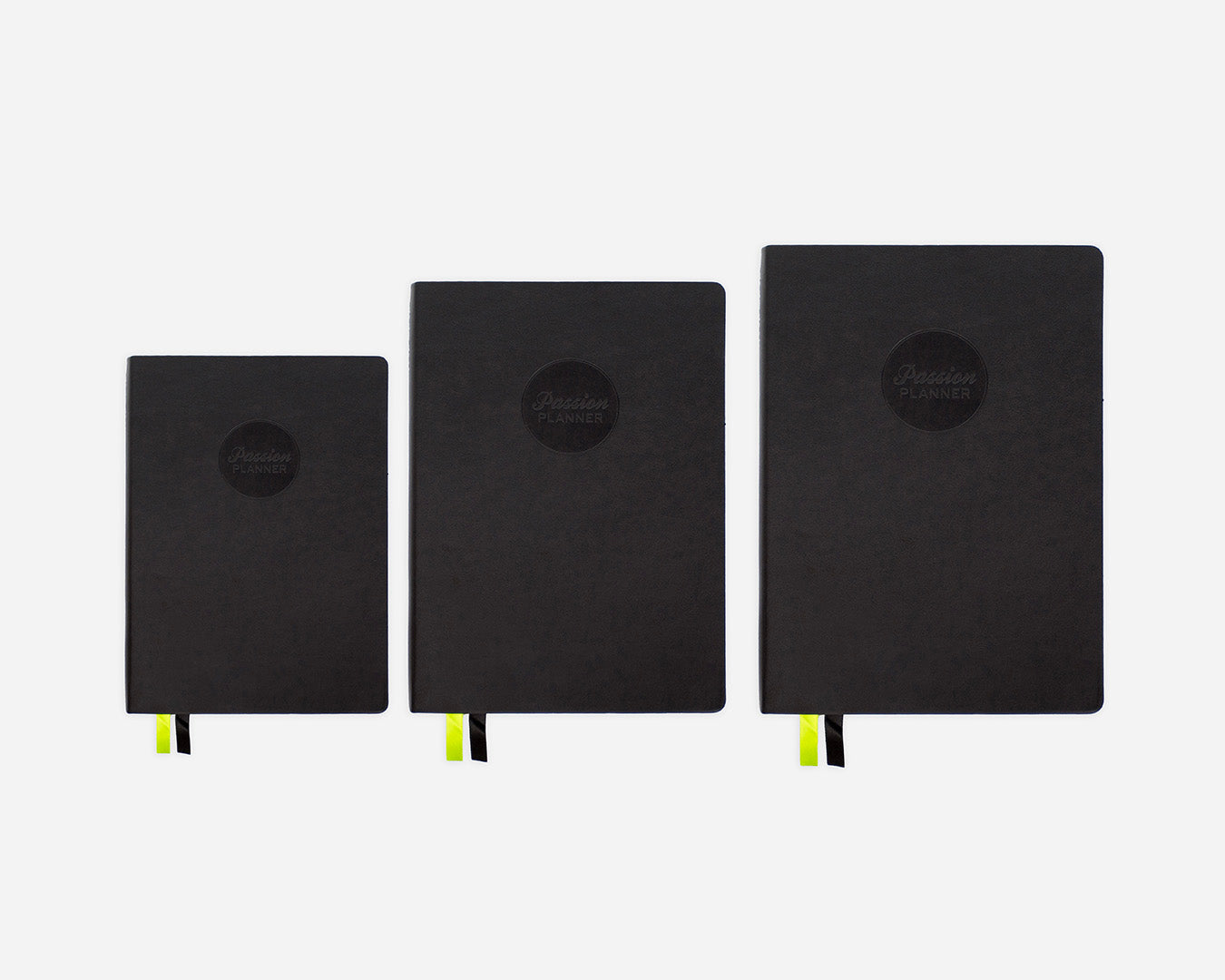 Three black mid-year planners of different sizes on a white background
